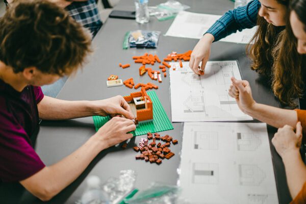 Students use Lego bricks to build models with mentors in a career connected learning program.